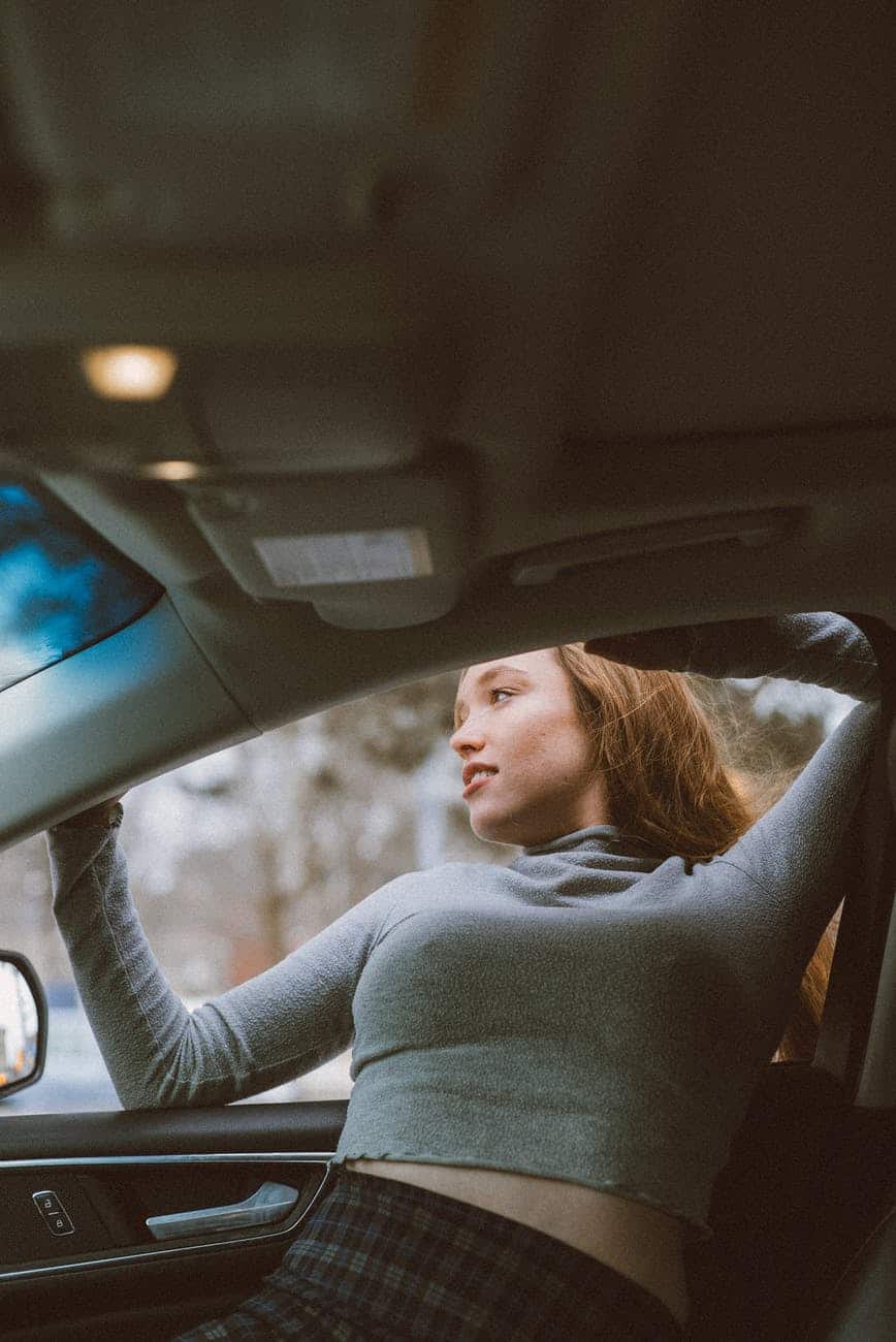 woman getting out of car through window