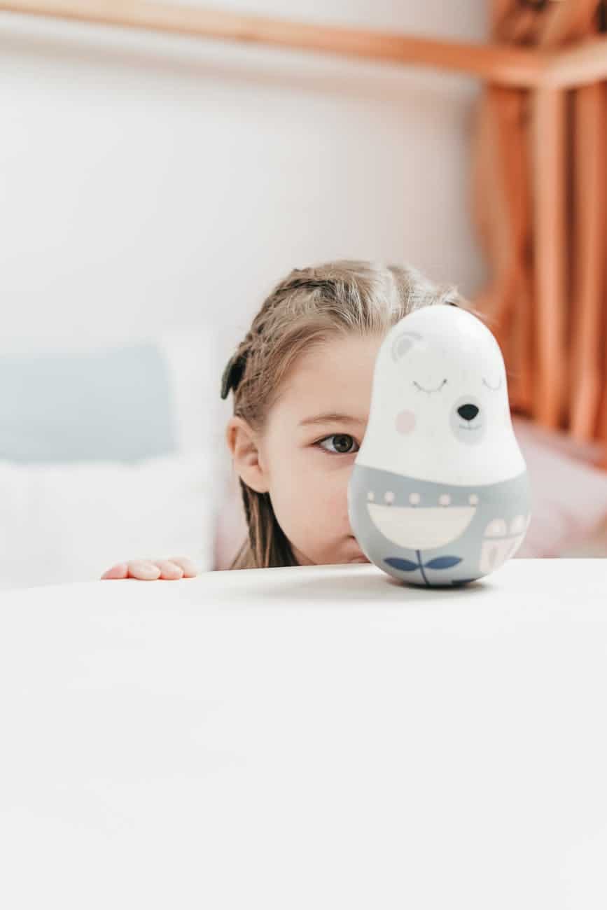 girl staring at a white and blue ceramic bird figurine