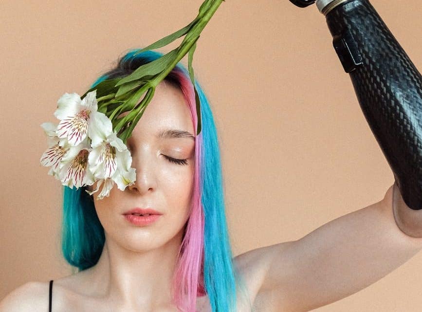 woman in black slip dress holding white flower upside down