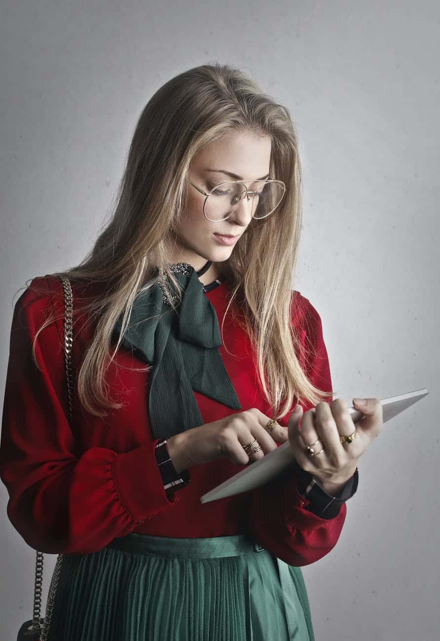 woman in red long sleeves holding a tablet