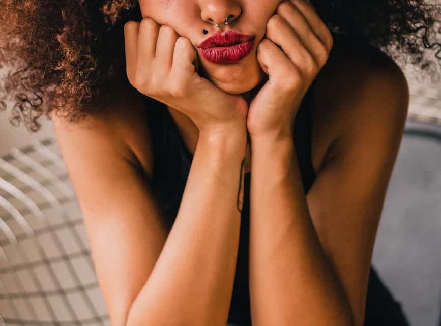 unhappy ethnic woman puffing cheeks with hands