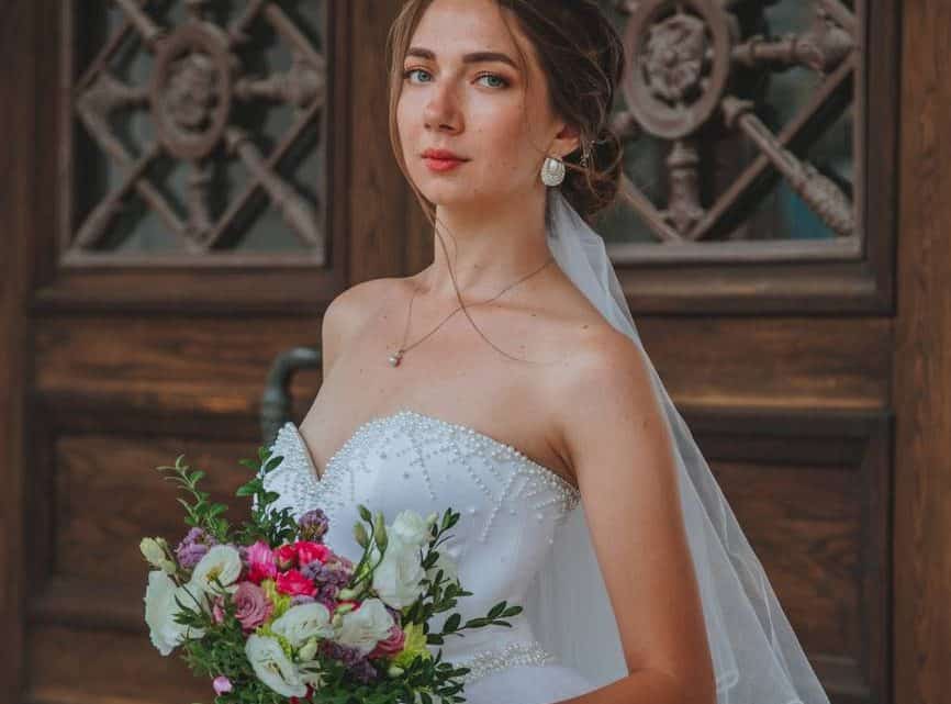 elegant bride standing near wooden door
