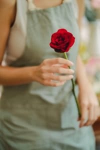 florist holding a red rose