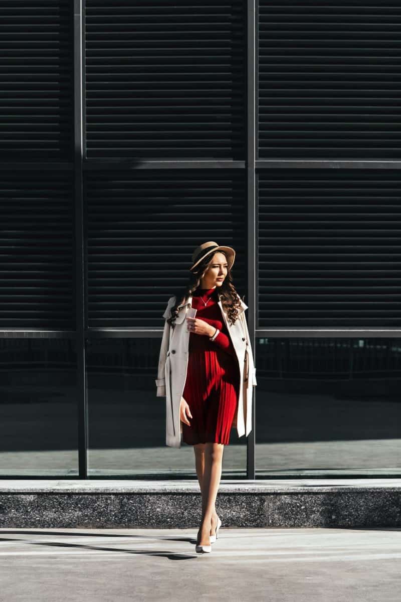 stylish woman crossing road against modern building